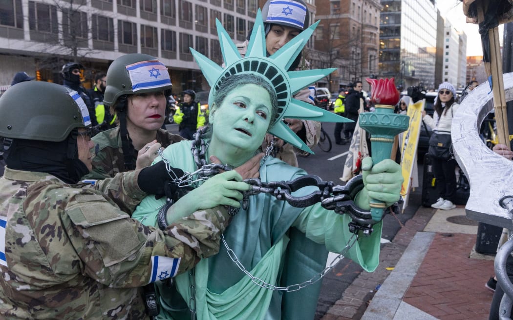 An activist dressed as the Statue of Liberty, draped in chains, as they rally in support of Palestinians during the "Arrest Netanyahu at the White House Rally" near the White House in Washington, D.C., on February 4, 2025. Netanyahu met with President Donald Trump at the White House for crucial talks on the truce with Hamas, as the U.S. president suggested permanently resettling Palestinians from war-battered Gaza. (Photo by Hanna Leka / Middle East Images / Middle East Images via AFP)