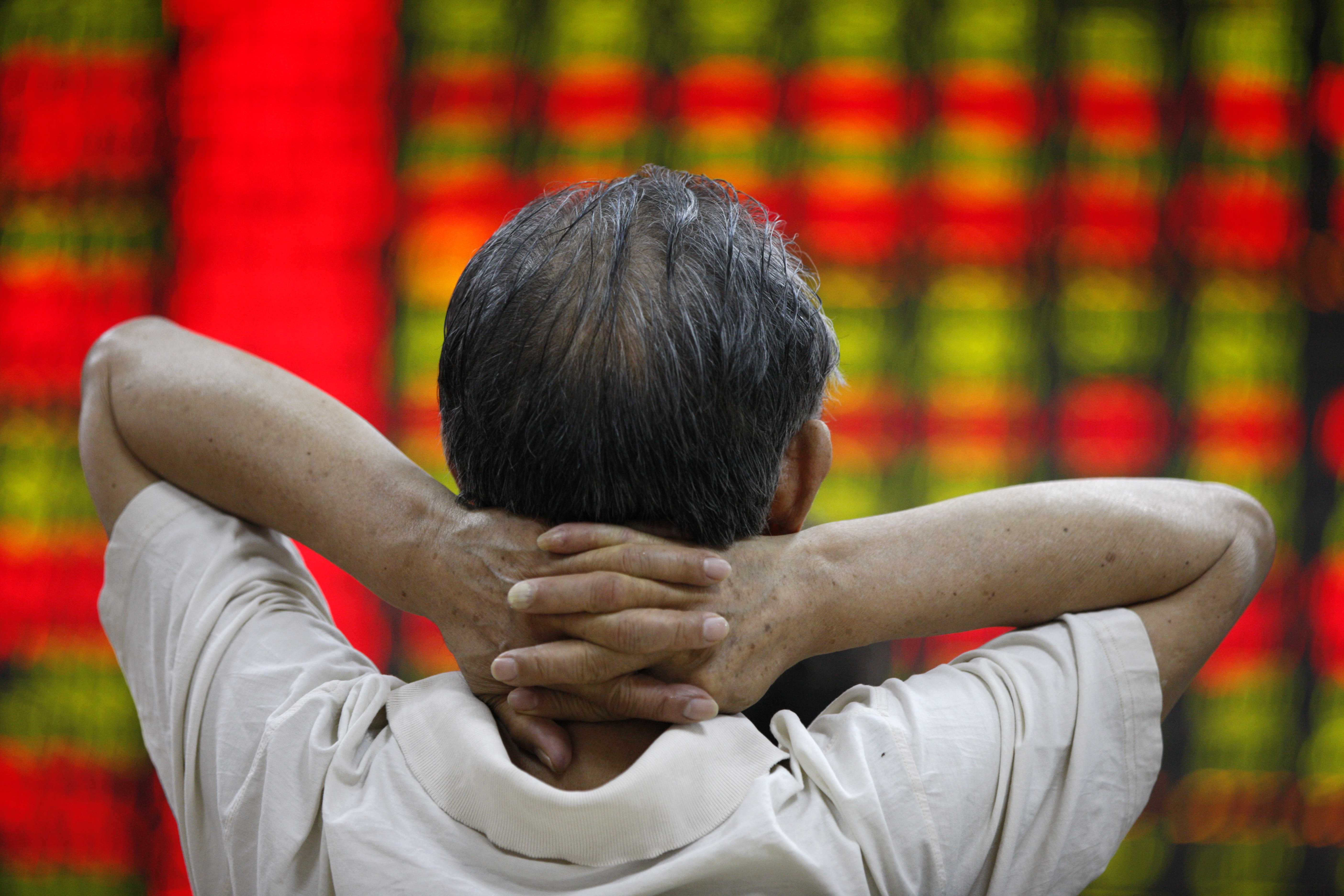 A man watches a screen board at a stocks market in Huaibei, east China's Anhui Province, July 6, 2015.