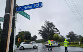 Police stop traffic at a road block on Motutara Road, Muriwai, on 14 February, near where a landslide came down onto two houses late on Monday 13 February, 2023.