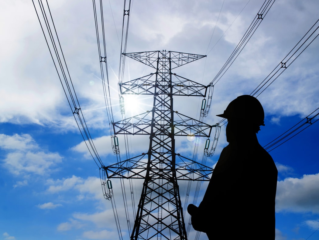 silhouette of engineers standing at electricity station