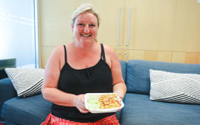Lunch with Crunch founder Claire Kelly holding a chicken katsu dish her company has provided to schools