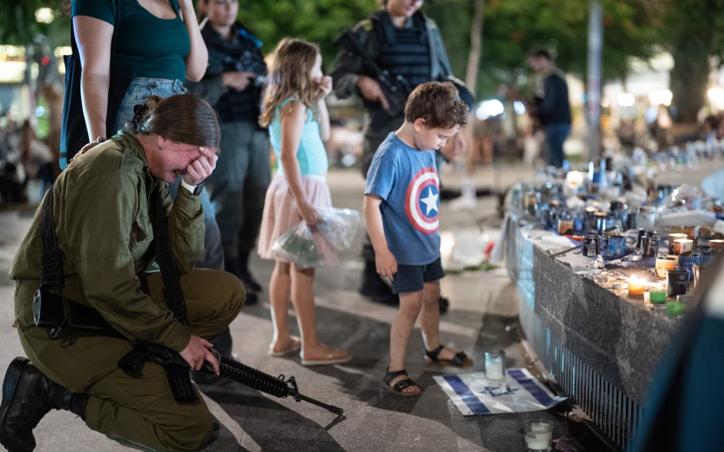 People gather and light candles to remember the victims who were murdered by Hamas militants at Dizengoff Square in Tel Aviv, 22 October, 2023 (Photo by Dima Vazinovich / Middle East Images / Middle East Images via AFP)