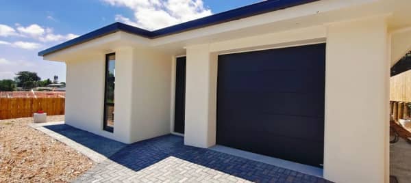A paved driveway leads to a single car garage.