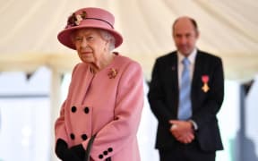 Britain's Queen Elizabeth II speaks with staff including Professor Tim Atkins (R), who was honoured for his work on the 2018 Novichok incident and has been involved in the fight against Covid-19.