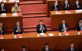 China's President Xi Jinping (centre) applauds after the vote on a proposal to draft a Hong Kong security law during the closing session of the National People's Congress at the Great Hall of the People in Beijing.
