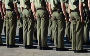 Australian soldiers stand at attention.