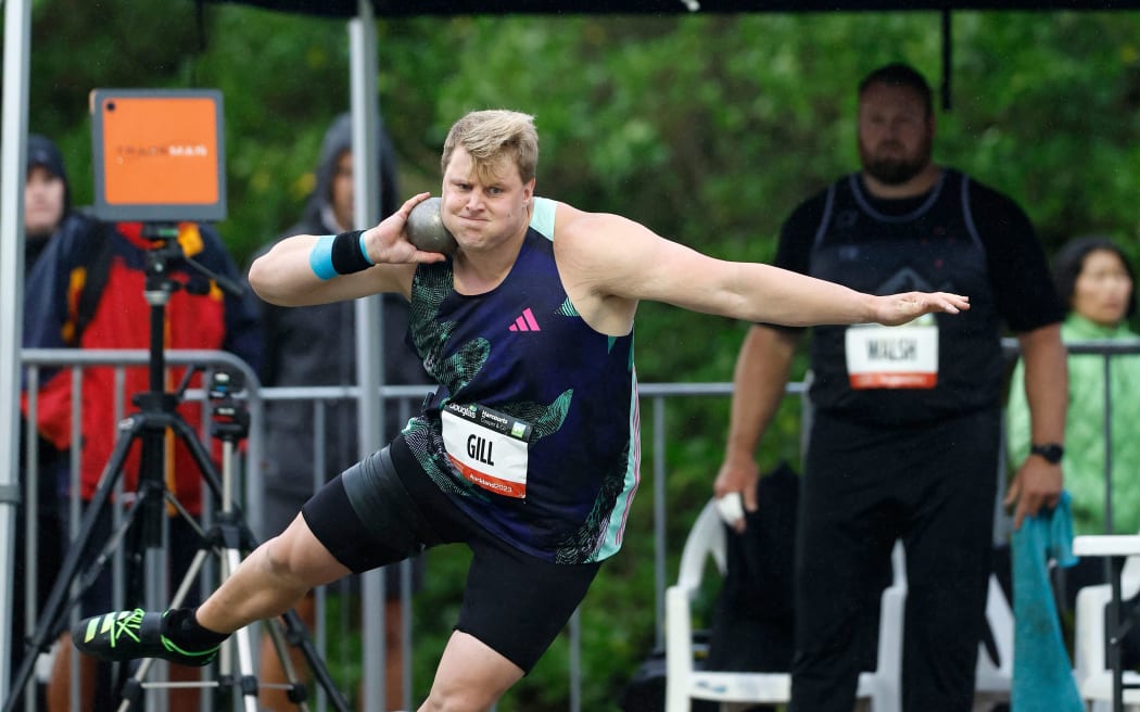 Jacko Gill on his way to winning the shot put at the 2023 Sir Graeme Douglas International Athletic meet with Tom Walsh watching on.