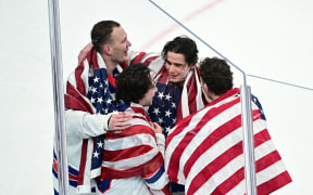 USA's Jack Hughes (C) celebrates with  teammates after winning  the men's gold medal ice hockey match against Canada, Winter Olympics, 2026.