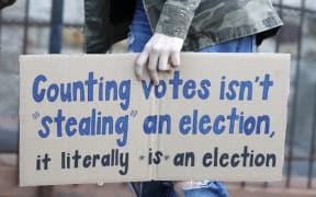 A protestor who wants every vote counted from the 2020 presidential election, carries a sign as they march down Woodward Avenue on November 4, 2020 in Detroit, Michigan.