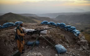 An Afghan militia fighter keeps a watch at an outpost against Taliban insurgents at Charkint district in Balkh Province on 11 July, 2021.