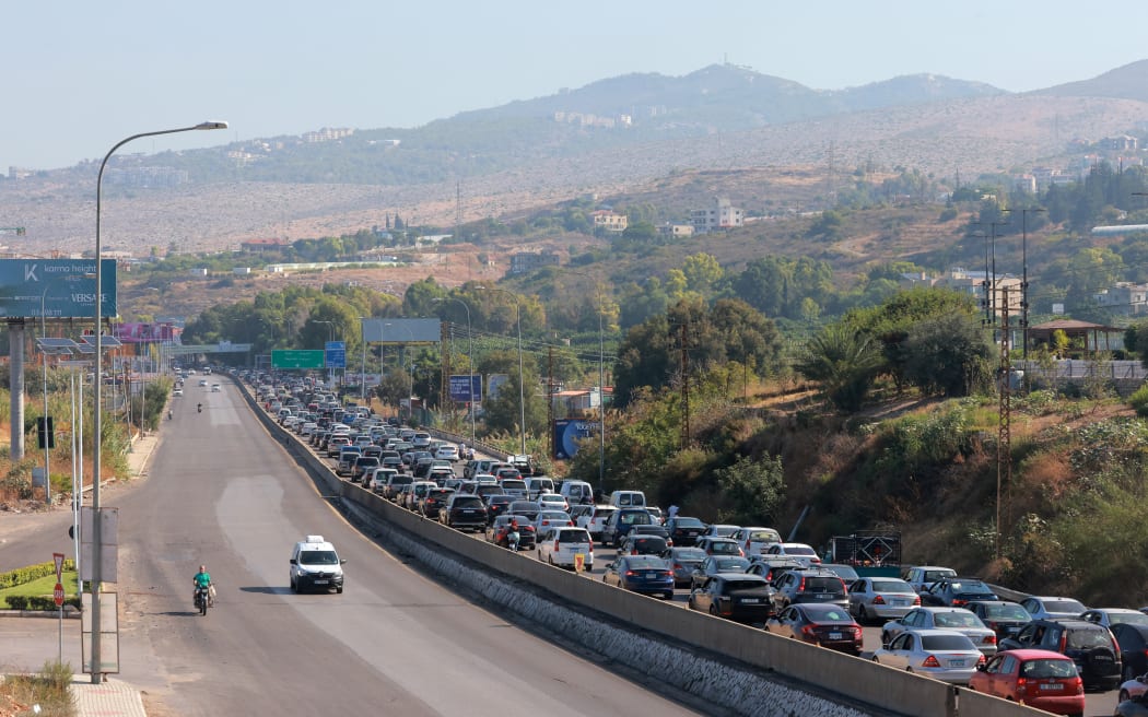 Vehicles wait in traffic in the town of Damour, south of the capital Beirut on September 24, 2024, as people flee southern Lebanon. Israel announced dozens of new air strikes on Hezbollah strongholds in Lebanon on September 24, a day after 492 people, including 35 children, were killed in the deadliest bombardment since a devastating war in 2006. (Photo by Ibrahim AMRO / AFP)