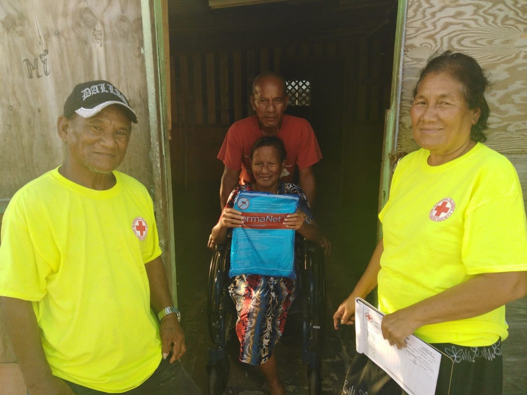 Marshall Islands Red Cross volunteers Randy Balos (left) and Lamjok Alik (right) deliver mosquito nets in Majuro