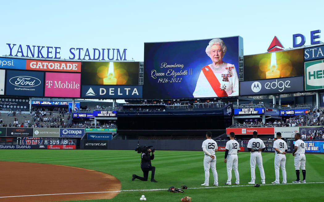 Members of the New York Yankees stand during a moment of silence in honor of Queen Elizabeth II prior to the game against the Minnesota Twins at Yankee Stadium on September 08, 2022 in the Bronx borough of New York City.   Mike Stobe/Getty Images/AFP (Photo by Mike Stobe / GETTY IMAGES NORTH AMERICA / Getty Images via AFP)