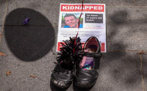 A poster bearing a photo of Israeli hostage Tal Haimi is seen as members of the Australian Jewish community participate in a gathering called ‘Balloons of Hope’, which represents Israeli hostages who are currently being held by the Palestinian group Hamas, in Sydney on October 27, 2023. Thousands of civilians, both Palestinians and Israelis, have died since October 7, 2023, after Palestinian Hamas militants based in the Gaza Strip entered southern Israel in an unprecedented attack triggering a war declared by Israel on Hamas with retaliatory bombings on Gaza. (Photo by DAVID GRAY / AFP)