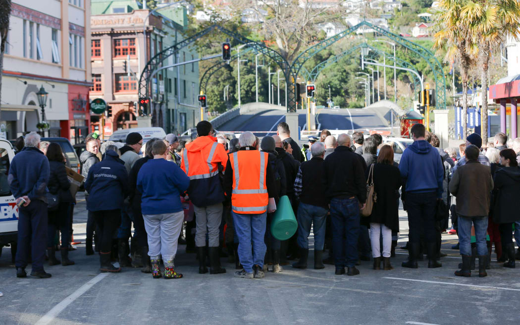 Whanganui business owners wait at the cordon this morning to see their riverside properties for the first time.