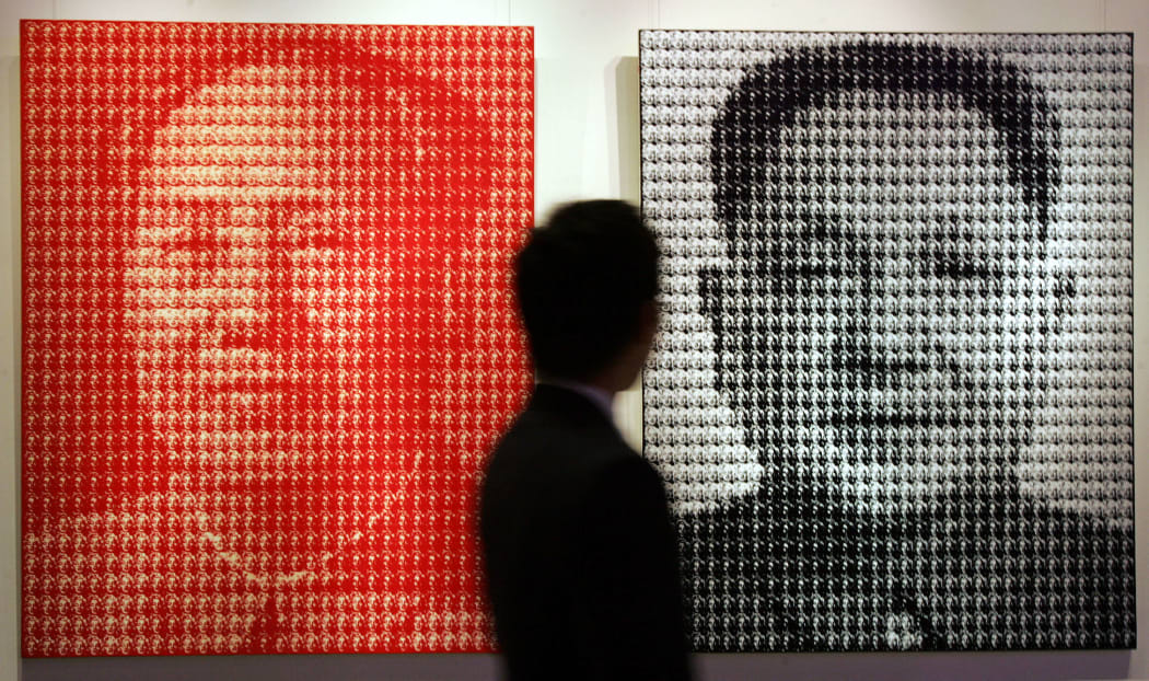 A prospective buyer views two paintings by South Korean artist Kim Dong Yoo entittled "Mao Zedong (L) and Deng Xiaoping (R)" prior to it going under the hammer at Christie's Spring sale, in Hong Kong 27 May 2007.