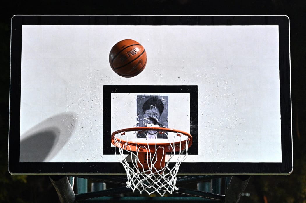 This picture taken on October 15, 2019, shows a basketball thrown by a protester before it hits a poster of Hong Kong Chief Executive Carrie Lam at the Southorn Playground in Hong Kong.