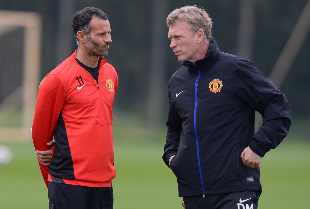 In happier times, Manchester United manager David Moyes (R) speaks to  midfielder Ryan Giggs .. the man who has temporarily replaced him.