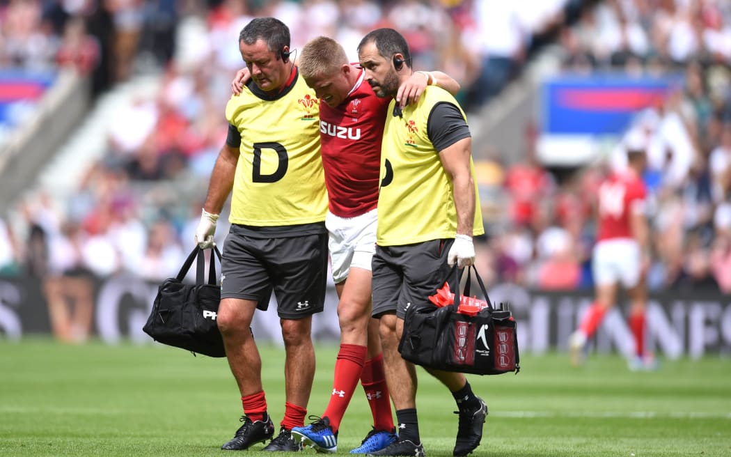 Gareth Anscombe of Wales leaves the field with an injury.
