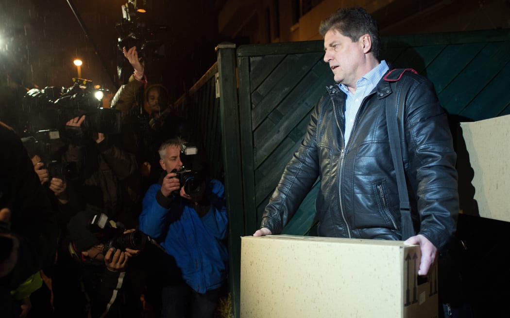 An Investigator carries a box out of a residential house where Andreas Lubitz used to live.