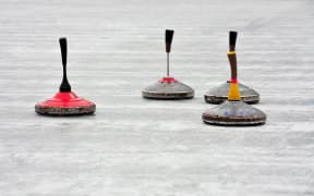 Stock photo of curling stones during an outdoor bonspiel.