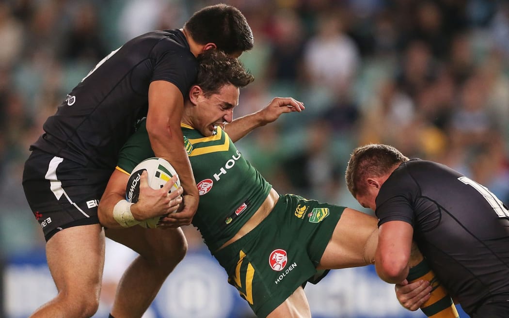 The Kangaroos fullback Billy Slater is tackled by two Kiwis players.