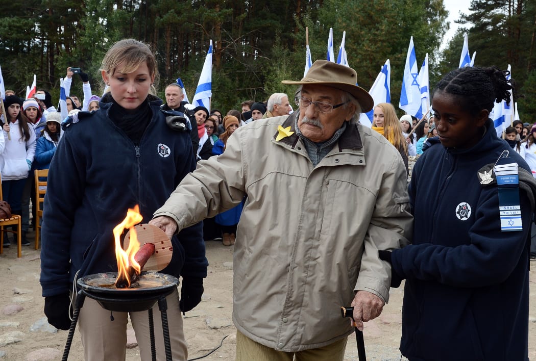Samuel Willenburg (centre) lighting a candle in front of the monument of Treblinka on 2 October 2013.