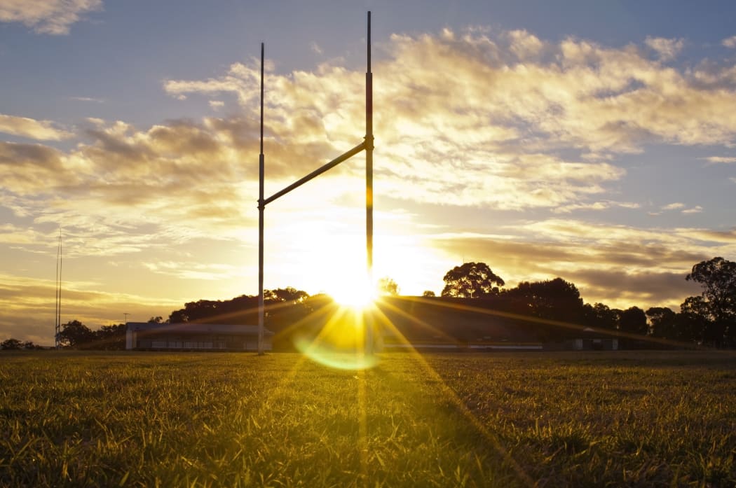 14437716 - goal posts for football, rugby union or league on field at sunset