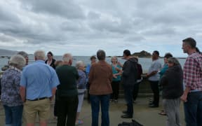 Ngati Toa kaumatua Te Waari Carkeek (in the centre-right wearing dark coloured hoodie) explains history of Taputeranga Island.