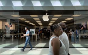 TOWSON, MARYLAND - JUNE 20: People walk past The Apple Store at the Towson Town Center mall, the first of the company's retail locations in the U.S. where workers voted over the weekend to unionize, on June 20, 2022 in Towson, Maryland. Following a late-pandemic era wave of workers demanding higher pay, better benefits and more negotiating leverage, 65 of the 98 workers at the Towson Apple Store voted to join the International Association of Machinists and Aerospace Workers union on June 18.   Chip Somodevilla/Getty Images/AFP (Photo by CHIP SOMODEVILLA / GETTY IMAGES NORTH AMERICA / Getty Images via AFP)