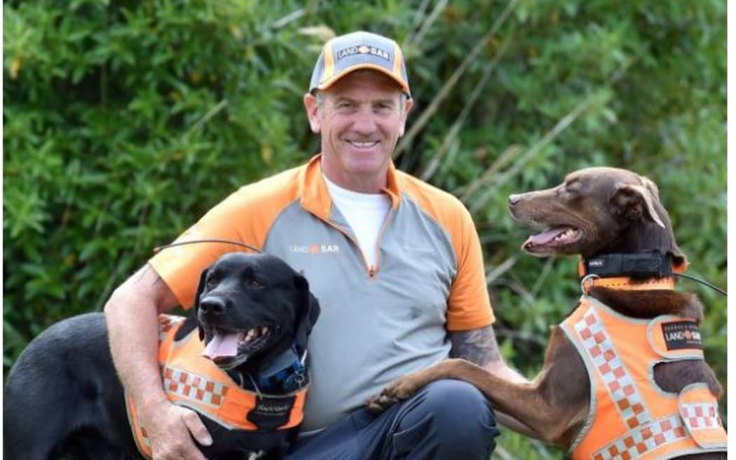 LandSAR dog handler Barry Dougherty plays with his two LandSAR area search dogs, black Labrador Jeffrey and kelpie Red, in Sidey Park yesterday. PHOTOS: PETER MCINTOSH