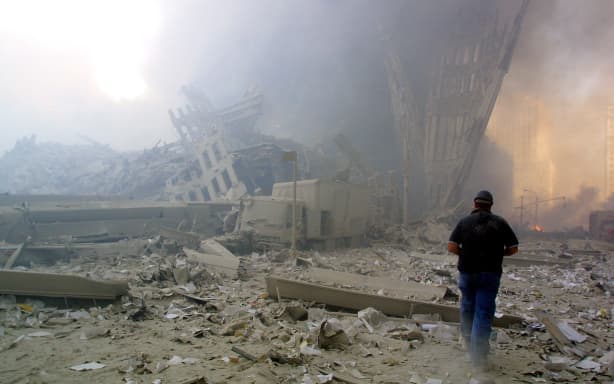 A man walks through the rubble after the collapse of the first World Trade Center tower, 11 September 2001, New York.