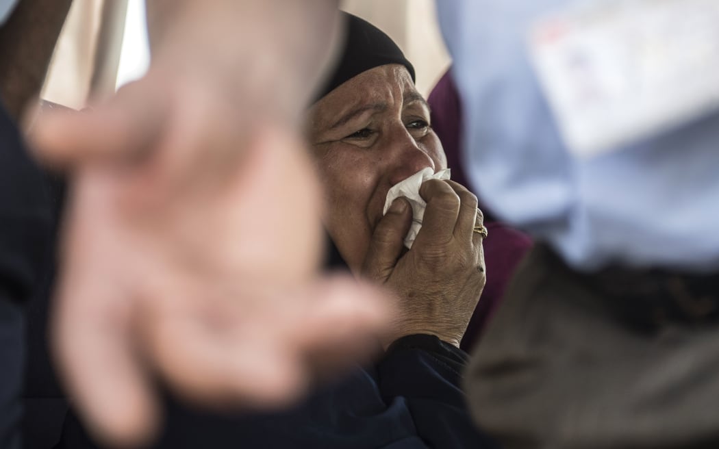 A relative of a passenger who was flying aboard an EgyptAir plane that vanished from radar en route from Paris to Cairo overnight cries as family members are transported by bus to a gathering point at Cairo airport on May 19, 2016.