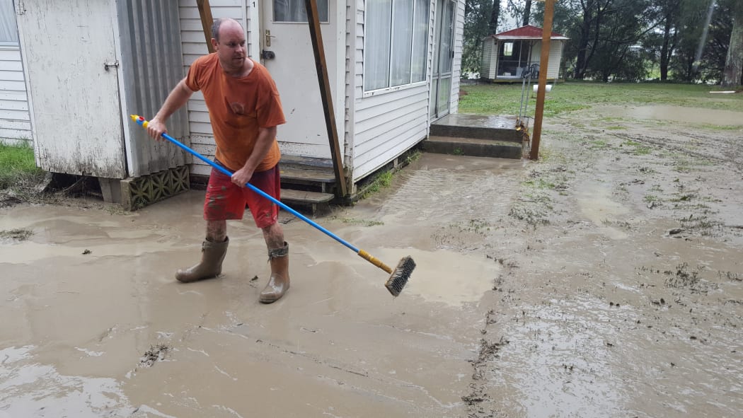 Eskdale Holiday Park campground owner Daniel Gale begins cleaning up after the flooding.