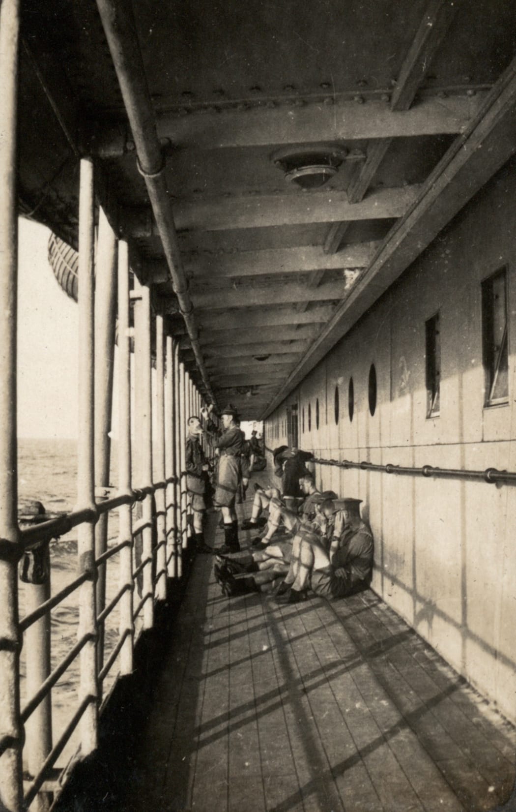 Troops sitting on the deck of the HMNZT Tahiti.