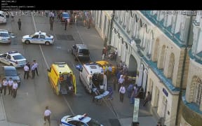 A handout CCTV picture released by the Moscow Municipal Traffic Regulation center shows Russian police officers and paramedics working at the scene after a taxi drove into a crowd injuring seven people.