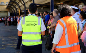 Commuters in Wellington wait for buses after a power outage cut most train services out of the region.