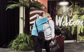A passenger is reunited with loved ones after the first quarantine-free Wellington flight from Australia disembarks.