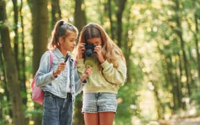 Two young girls exploring outside.