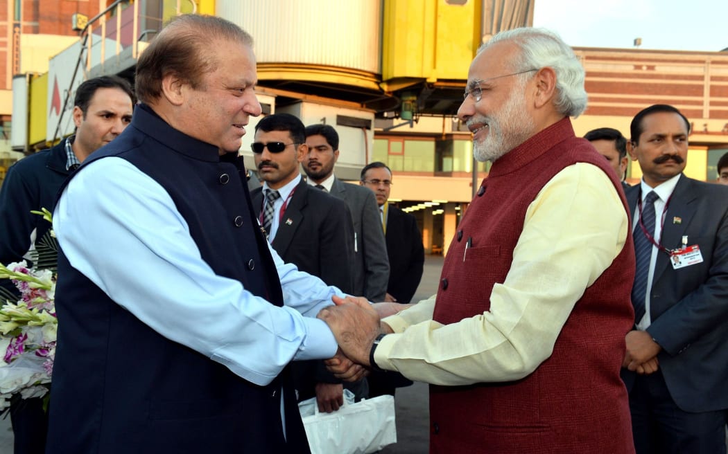 Prime Minister of Pakistan Nawaz Sharif (L) shakes hands with Indian Prime Minister Narendra Modi (R) at Allama Iqbal International Airport in Lahore, Pakistan on December 25, 2015.
