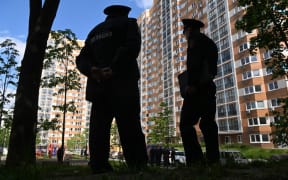 Police officers stand guard outside a multi-storey apartment building after a reported drone attack in Moscow on May 30, 2023. (Photo by Kirill KUDRYAVTSEV / AFP)