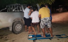 The refugee is loaded into a vehicle after collapsing at the detention centre.