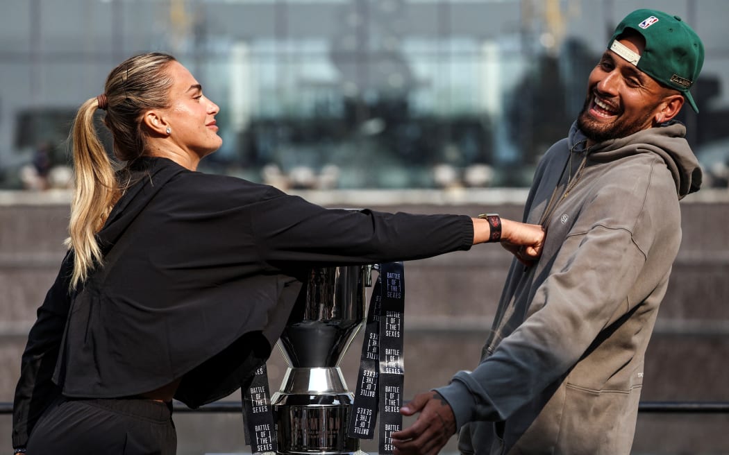 Aryna Sabalenka (L) pushes Australia's Nick Kyrgios during a press conference on the eve of the Battle of the Sexes exhibition match in Dubai.