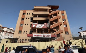 People and traffic pass the fence of the Nasser hospital in Khan Yunis which was hit in an Israeli strike at dawn that targeted the  southern Gaza Strip city on May 13, 2025. The Israeli military said it struck a Gaza hospital "housing Hamas militants" in a raid on May 13 which, according to the Palestinian group, killed a journalist who had been wounded in an Israeli attack last month and a number of civilians. (Photo by Eyad BABA / AFP)