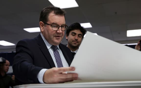 Grant Robertson looking over the first print of his first budget.