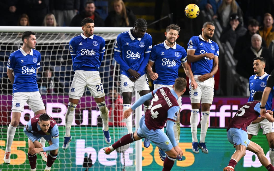 Everton's English defender #06 James Tarkowski (centre right) heads the ball away at a freekick taken by Burnley's Danish striker #34 Jacob Bruun Larsen (C) during the English Premier League football match between Burnley and Everton at Turf Moor in Burnley, north-west England on December 16, 2023. (Photo by Oli SCARFF / AFP) / RESTRICTED TO EDITORIAL USE. No use with unauthorized audio, video, data, fixture lists, club/league logos or 'live' services. Online in-match use limited to 120 images. An additional 40 images may be used in extra time. No video emulation. Social media in-match use limited to 120 images. An additional 40 images may be used in extra time. No use in betting publications, games or single club/league/player publications. /