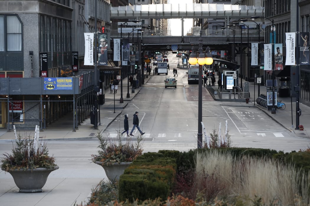 People walk along an empty Michigan Avenue in Chicago, Illinois, on March 21, 2020.