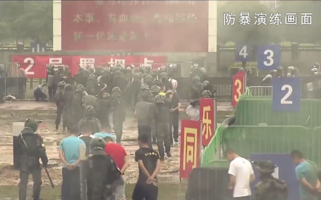 This screengrab taken from undated handout three-minute promotional video received on August 1, 2019 from China's People's Liberation Army (PLA) Hong Kong Garrison shows "protesters" being detained by PLA soldiers during an "anti-riot" drill in Hong Kong.