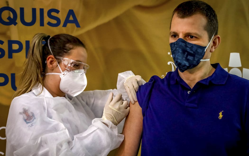Health worker and volunteer Luciano Marini receives a COVID-19 vaccine produced by Chinese company Sinovac Biotech at the Sao Lucas Hospital, in Porto Alegre, southern Brazil on August 08, 2020.