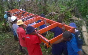 Villagers with the portable sawmill being used to mill timber for the post cyclone rebuild on Koro, Fiji